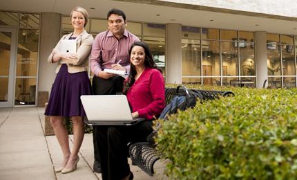 Three TCU Neeley MBA students sit outside the business building